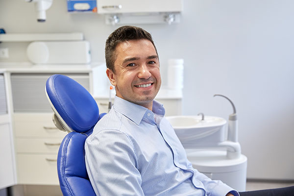A man sitting in a dental chair with a smile on his face.